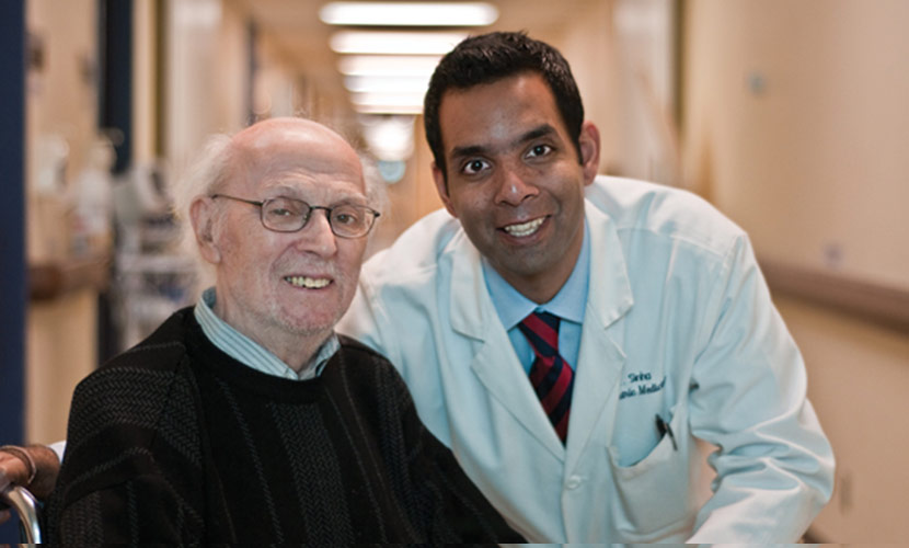 Photo of Samir Sinha with patient in hallway of hospital