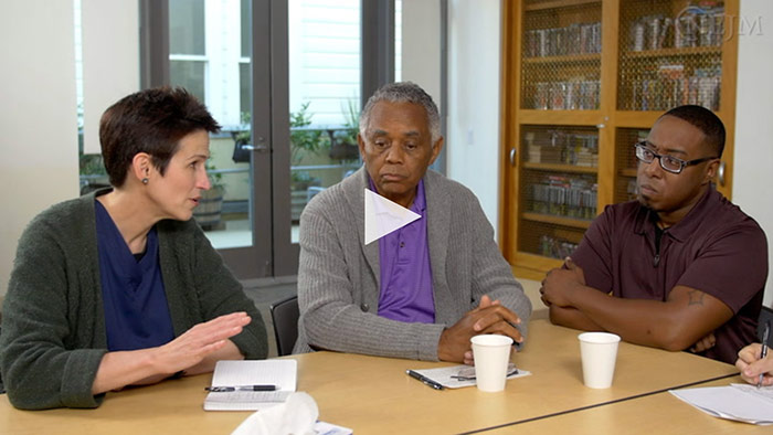 Video still of people talking with healthcare worker about their family member
